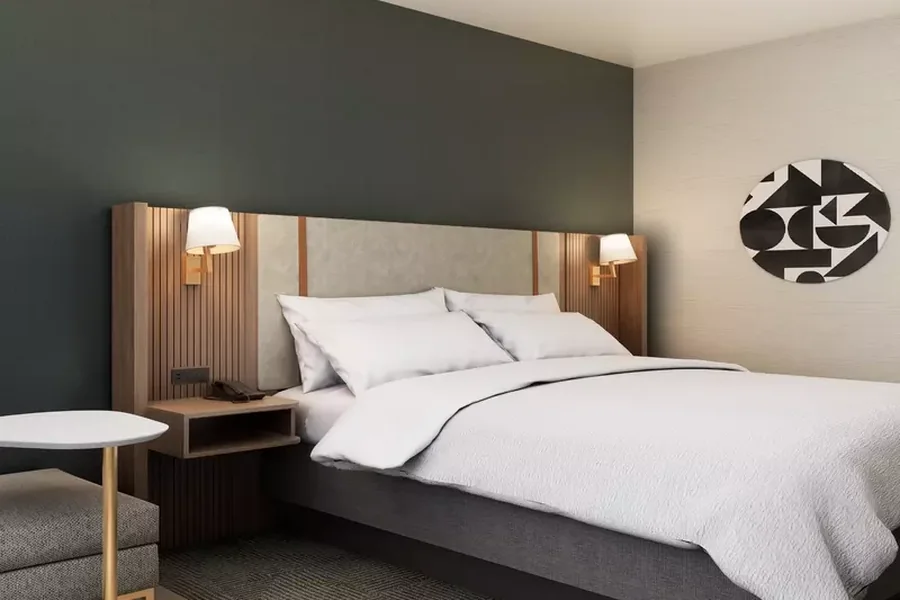 habitación de hotel con cama y cabecera integrada