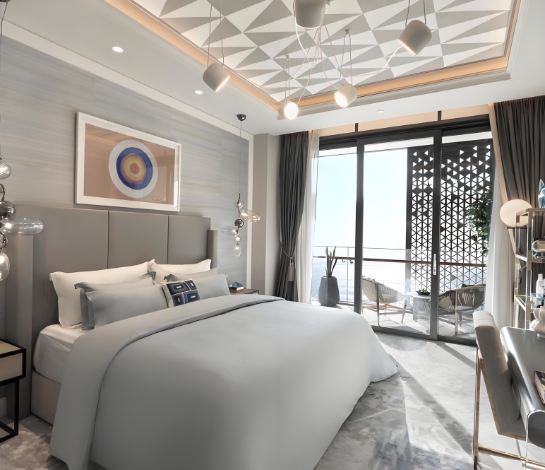 Habitación de hotel con cabecero tapizado, mesitas de noche, escritorio y mueble de minibar especificados en la unidad base