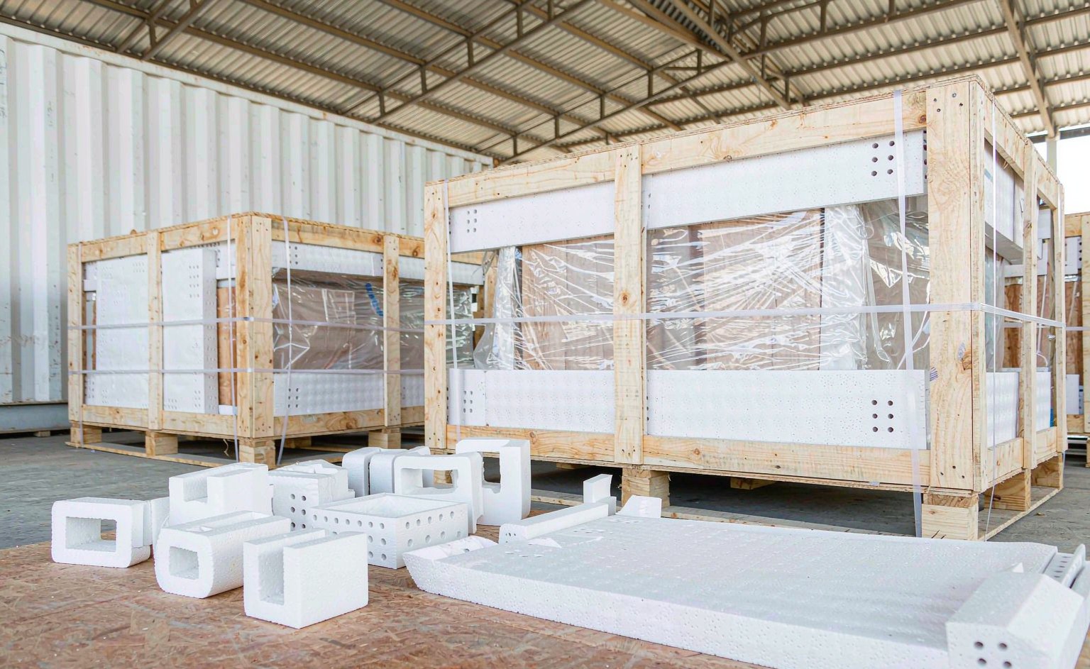 Cajones de exportación con protectores de esquina paletizados junto al contenedor antes de la carga